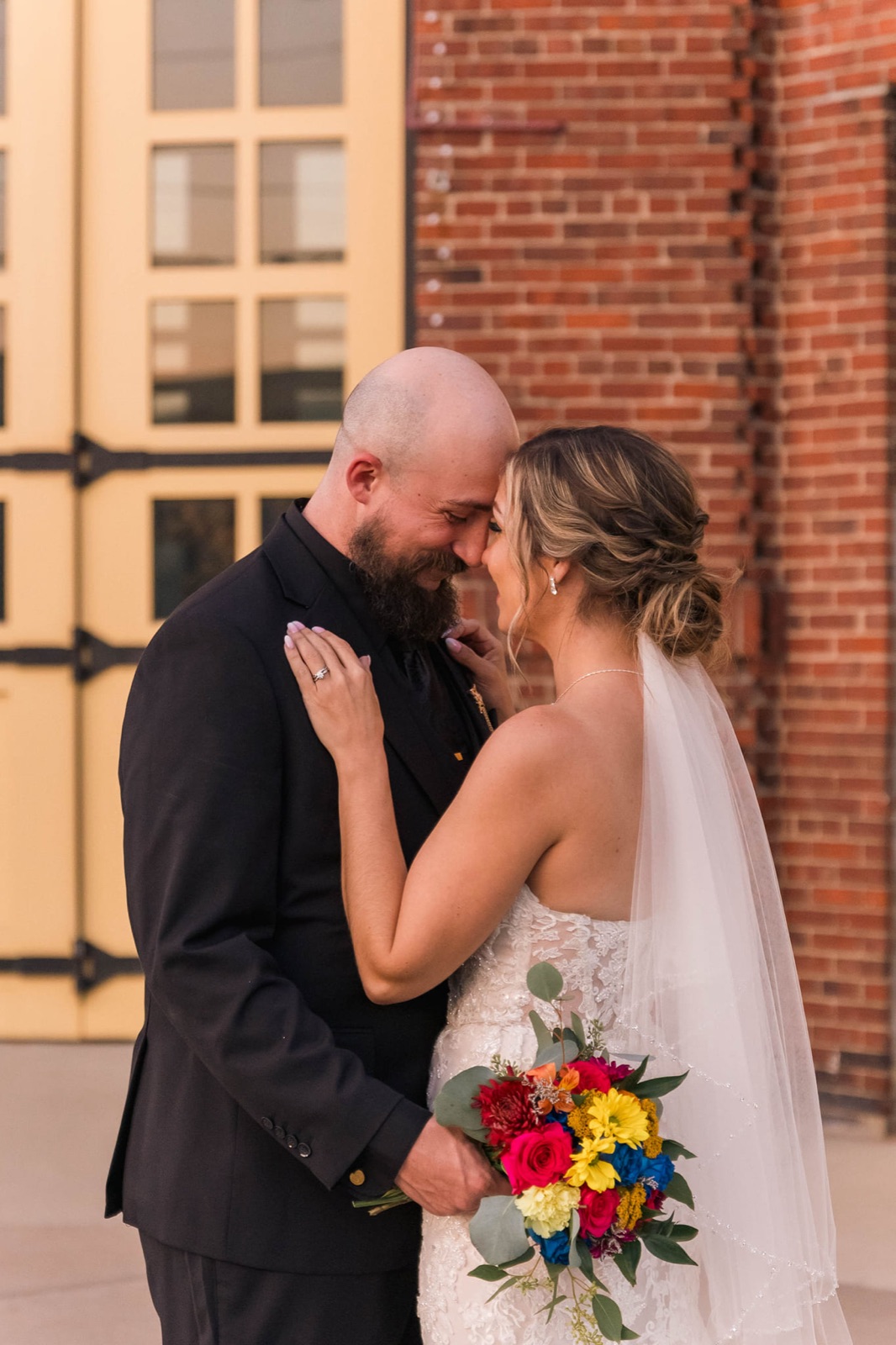 Bride and groom sharing a quiet moment outside a brick venue at a West Michigan wedding